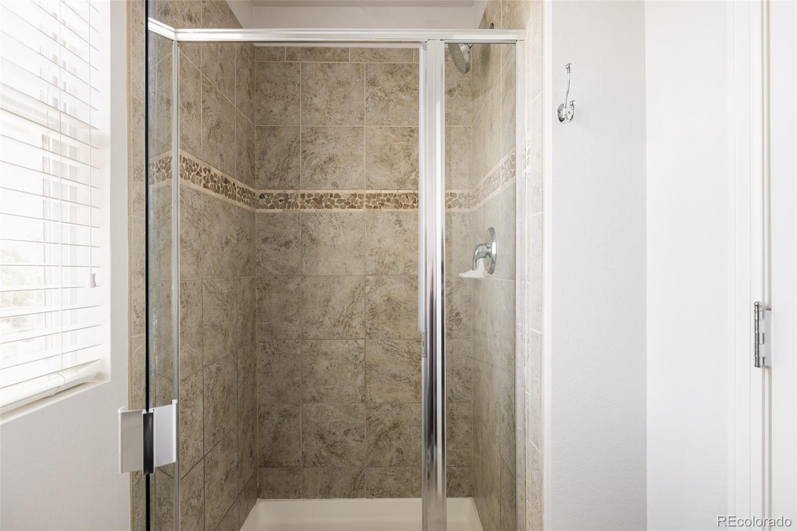 2899 Trinity Loop Broomfield, CO 80023 - Photo 19 of 33 a bathroom with a glass shower door