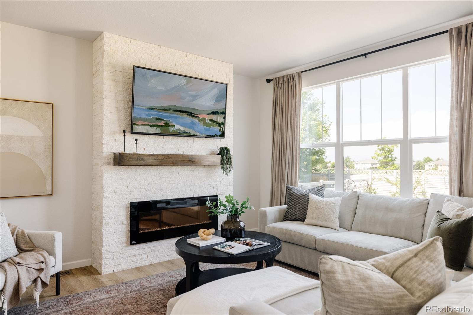 2899 Trinity Loop Broomfield, CO 80023 - Photo 3 of 33 a living room with furniture a fireplace and a large mirror