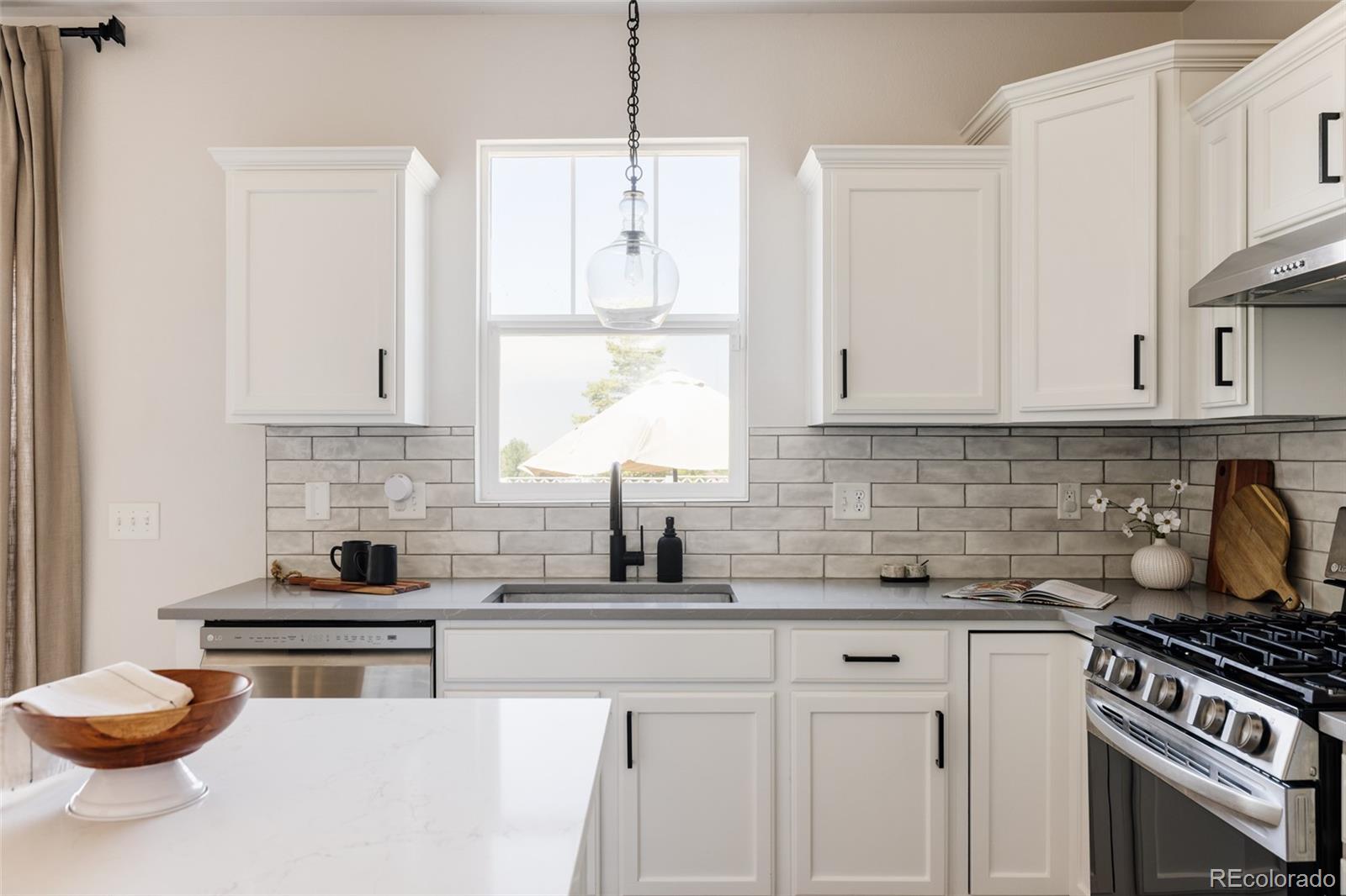 2899 Trinity Loop Broomfield, CO 80023 - Photo 9 of 33 a kitchen with stainless steel appliances a stove a white cabinets and a stove