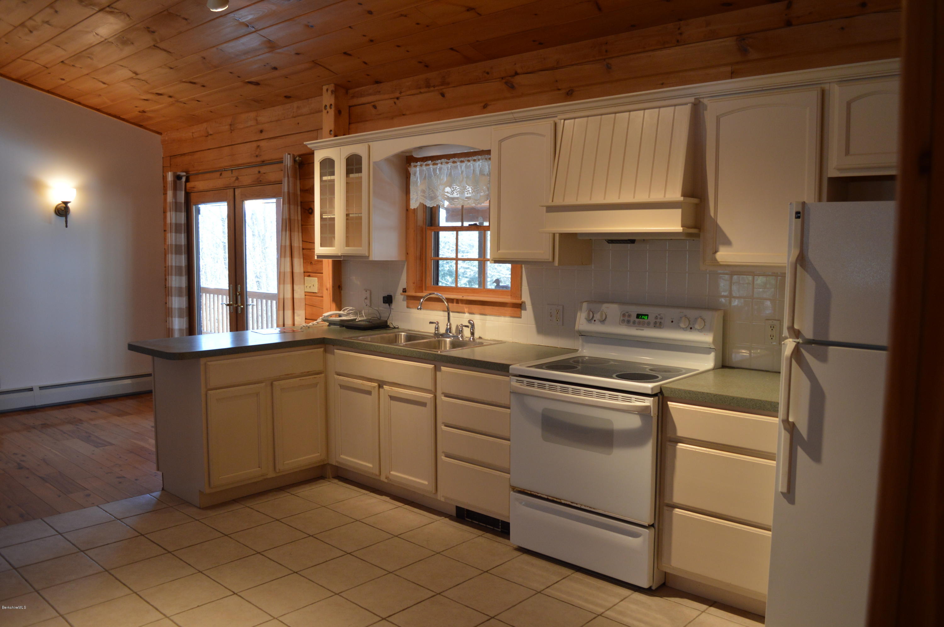 2034 West Center Road Otis, MA 01253 - Photo 11 of 50 a kitchen with granite countertop white cabinets and white appliances