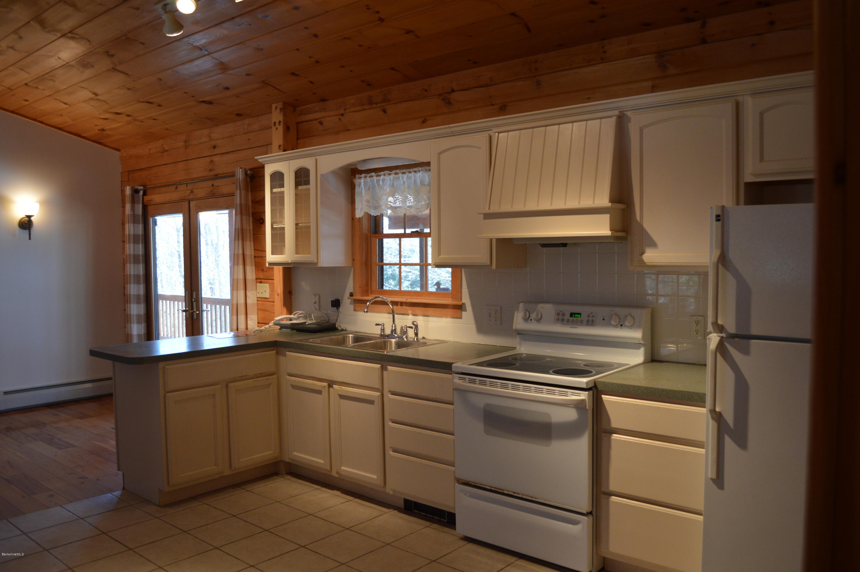 2034 West Center Road Otis, MA 01253 - Photo 14 of 50 a kitchen with white cabinets and white appliances