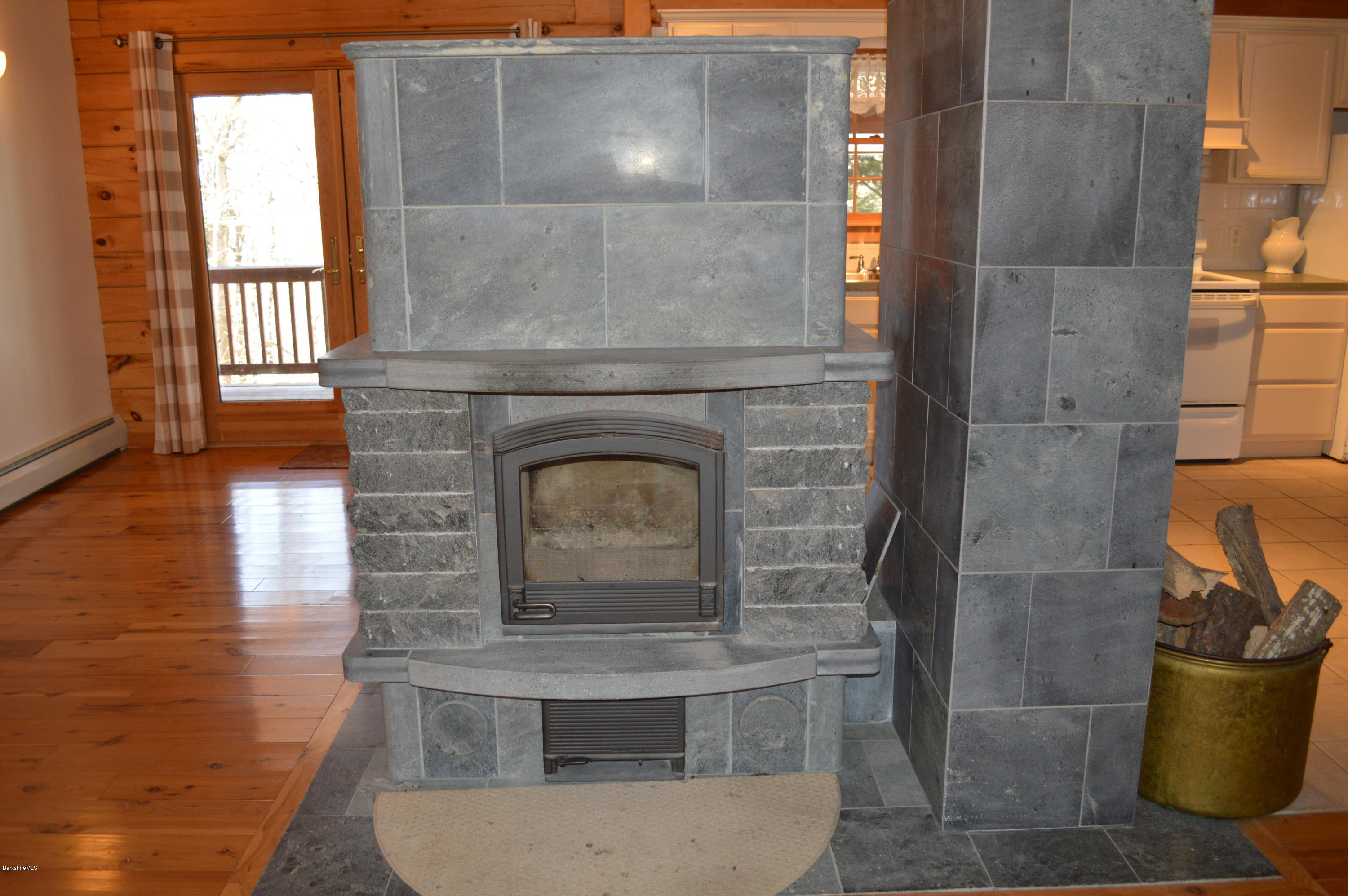 2034 West Center Road Otis, MA 01253 - Photo 35 of 50 a living room with a fireplace and a wooden floor