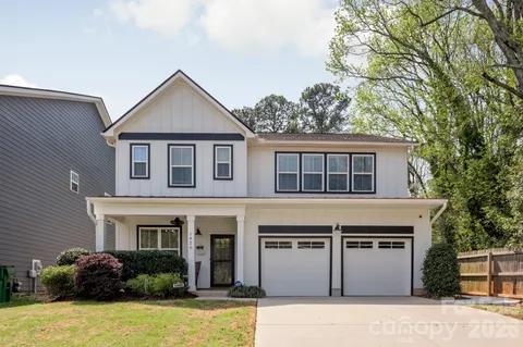 a front view of house with yard and trees in the background