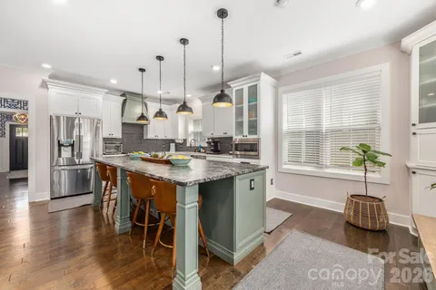 a living room with furniture kitchen view and a chandelier