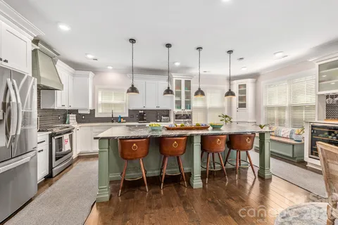 a spacious bedroom with a large bed a chandelier and a flat tv screen