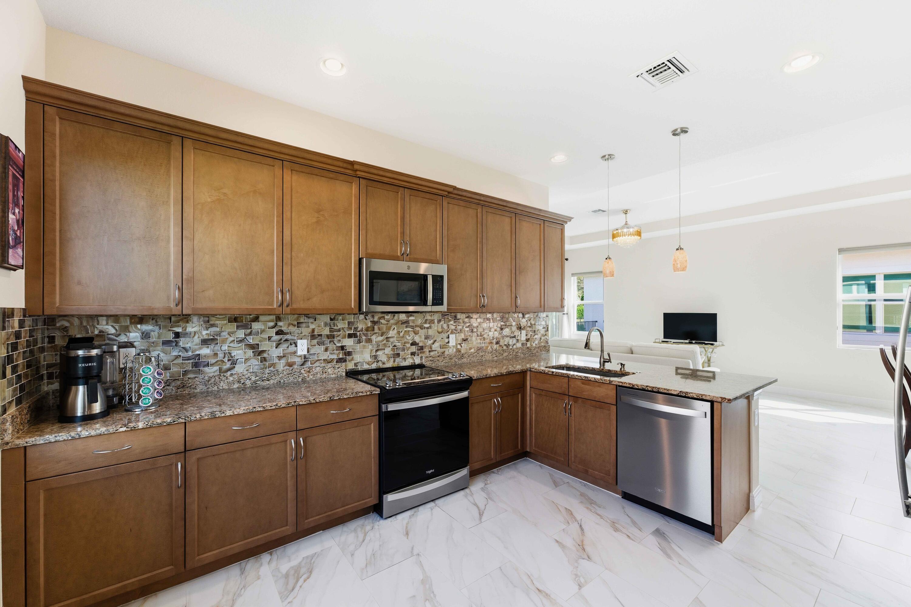 11473 Southwest Visconti Way Port St. Lucie, FL 34986 - Photo 13 of 69 a kitchen with stainless steel appliances granite countertop a sink stove and refrigerator