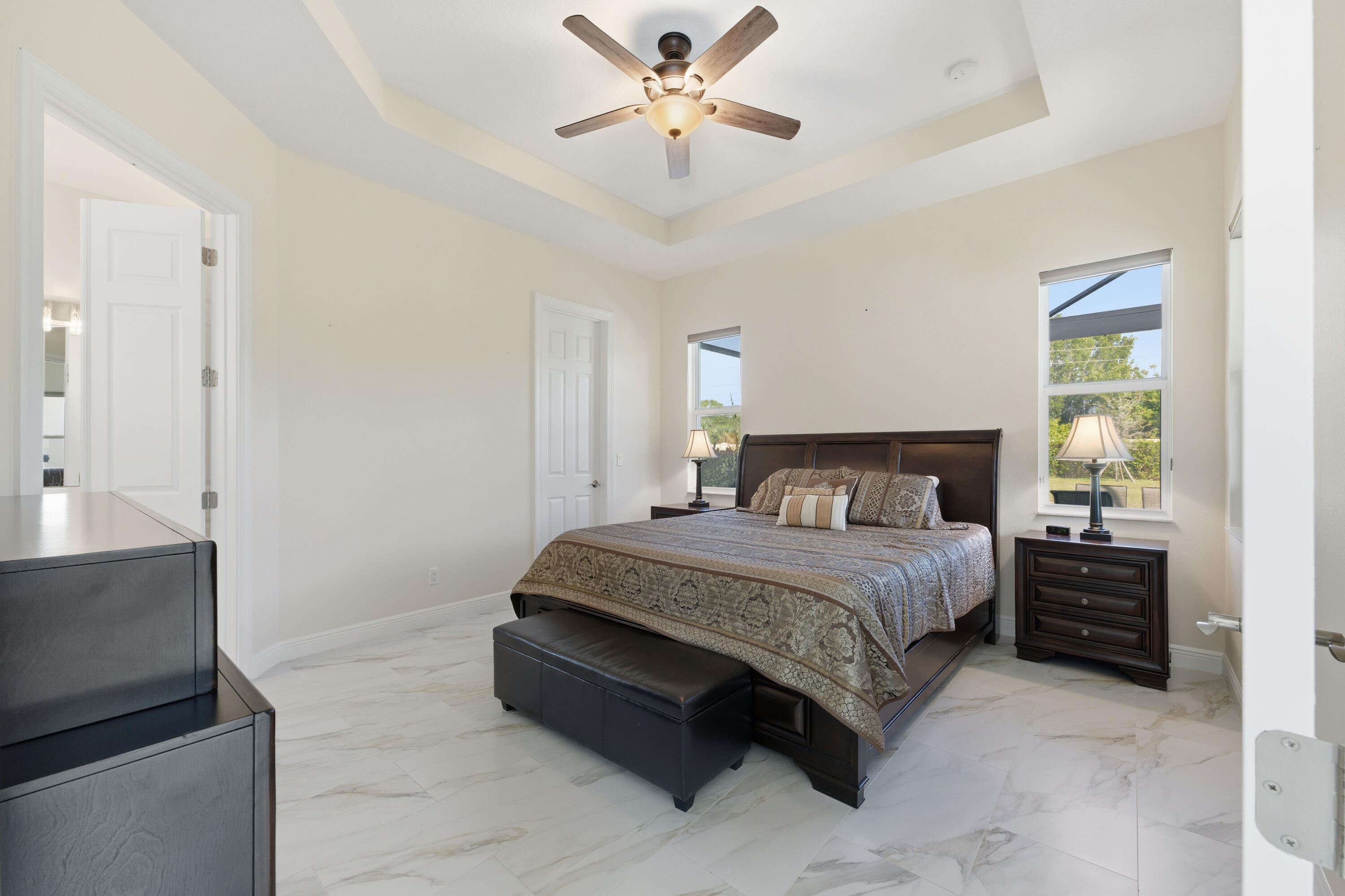 11473 Southwest Visconti Way Port St. Lucie, FL 34986 - Photo 14 of 69 a spacious bedroom with a bed and a chandelier