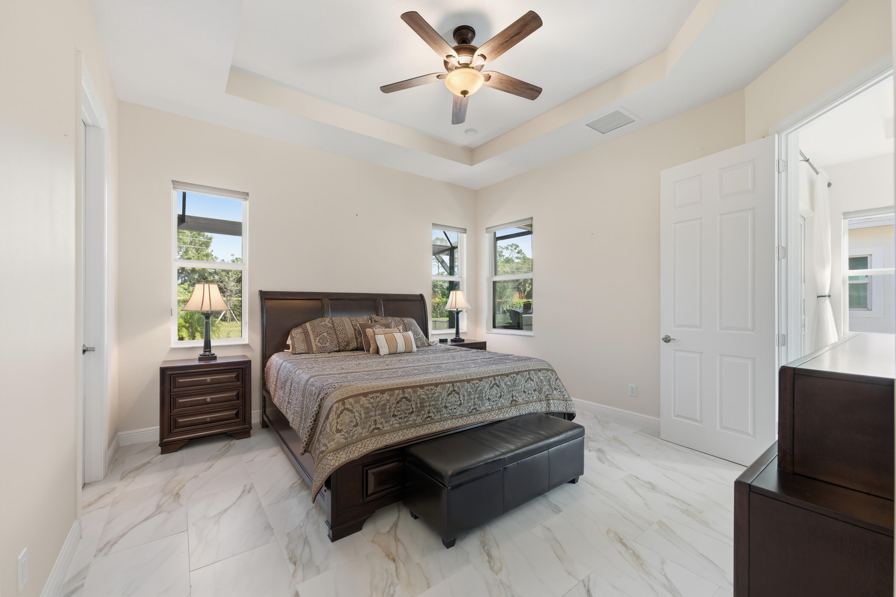 11473 Southwest Visconti Way Port St. Lucie, FL 34986 - Photo 15 of 69 a spacious bedroom with a bed and a chandelier