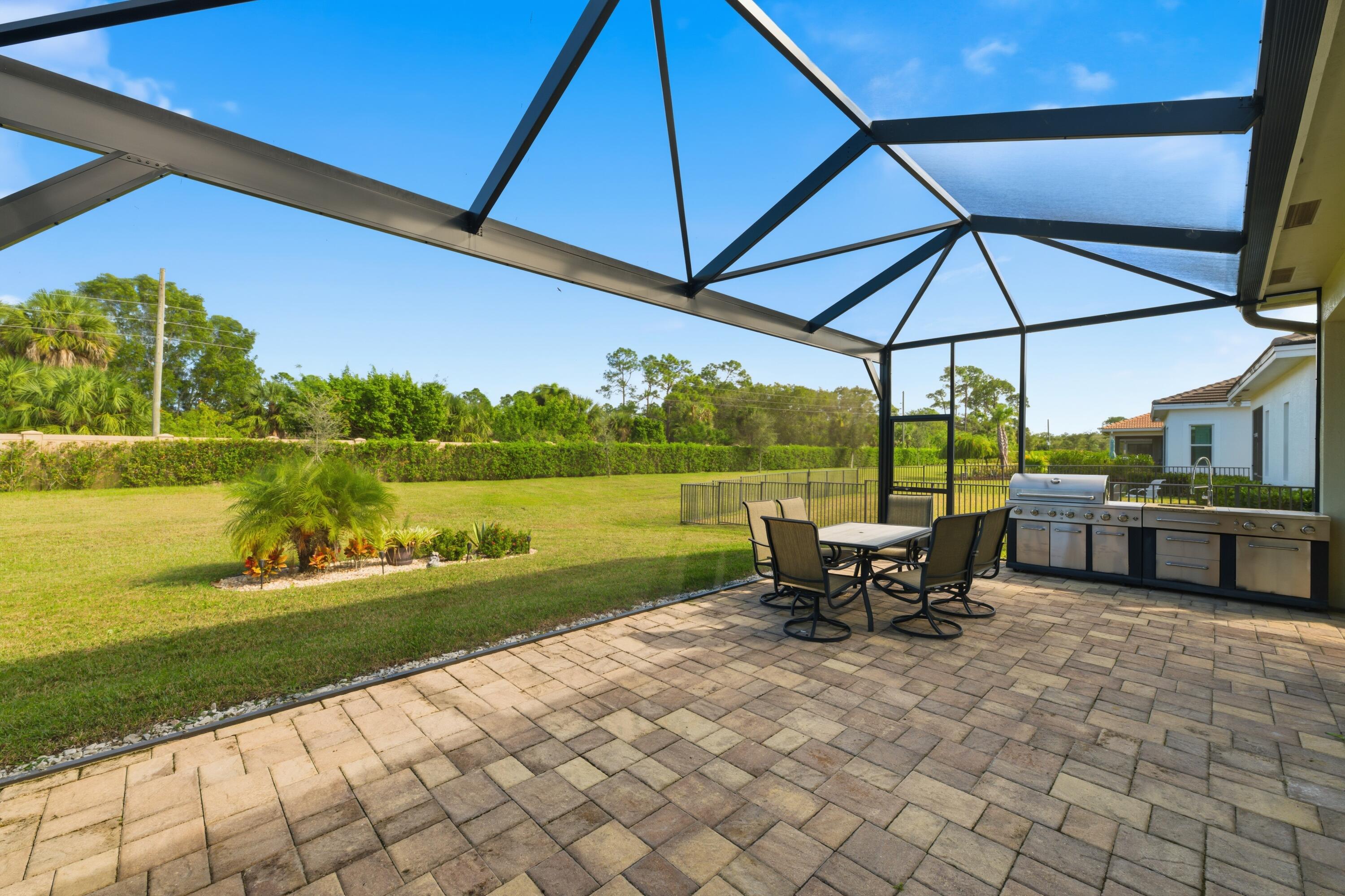 11473 Southwest Visconti Way Port St. Lucie, FL 34986 - Photo 24 of 69 a view of a lake with a table and chairs under an umbrella