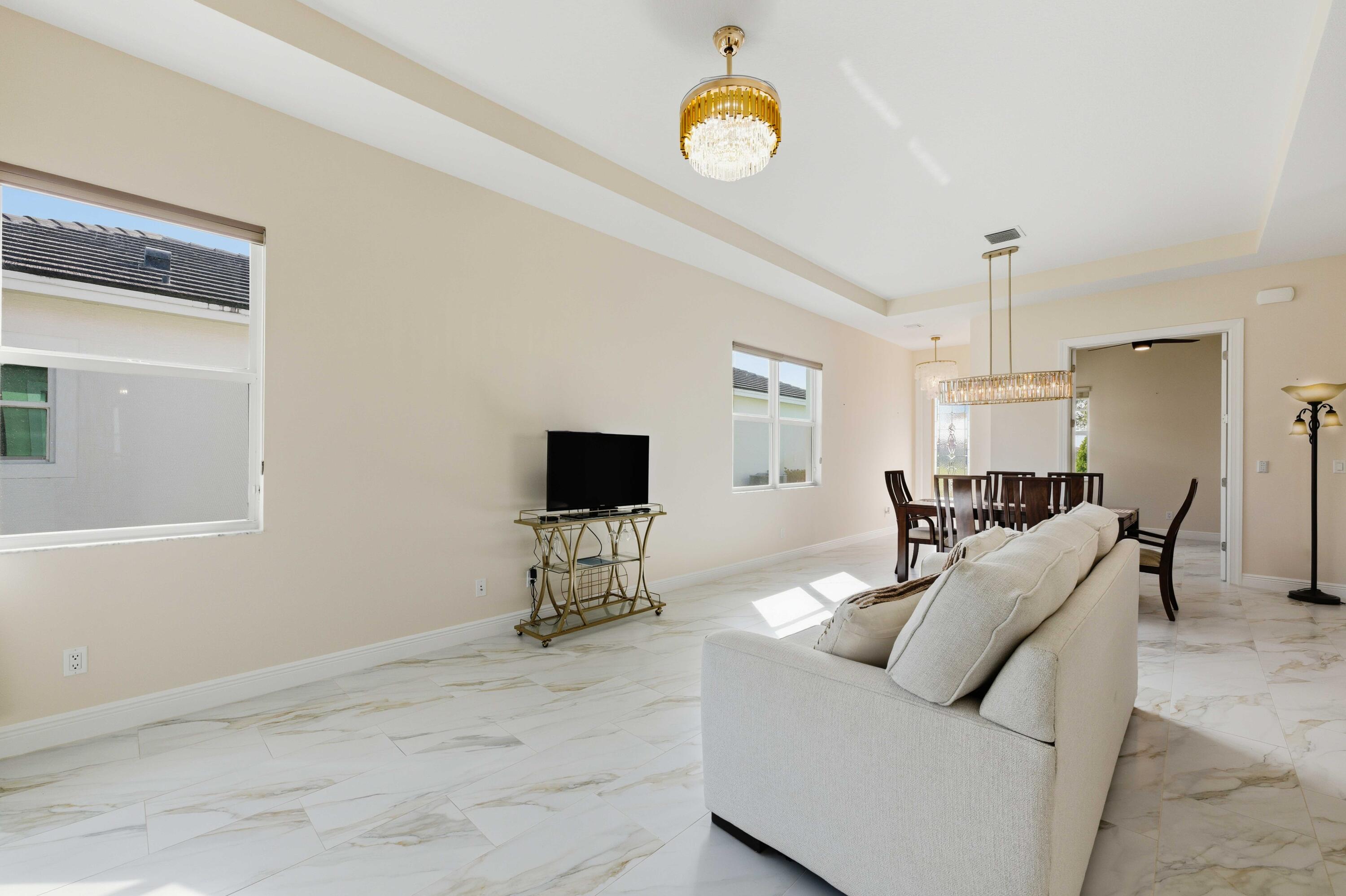11473 Southwest Visconti Way Port St. Lucie, FL 34986 - Photo 8 of 69 a living room with furniture a window and a flat screen tv