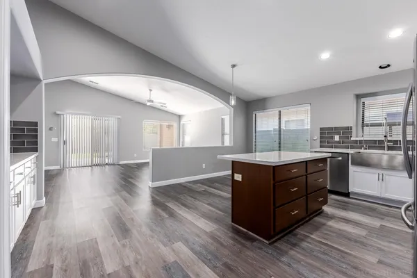 a kitchen with wooden floors and white walls