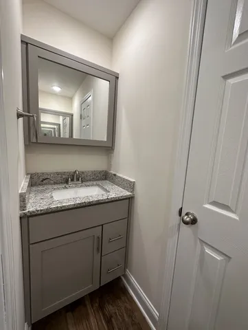 a bathroom with a granite countertop sink toilet and mirror