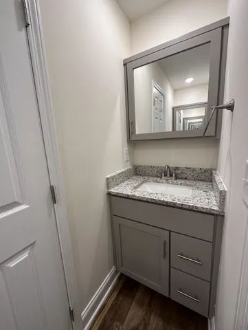 a bathroom with a granite countertop sink and a mirror