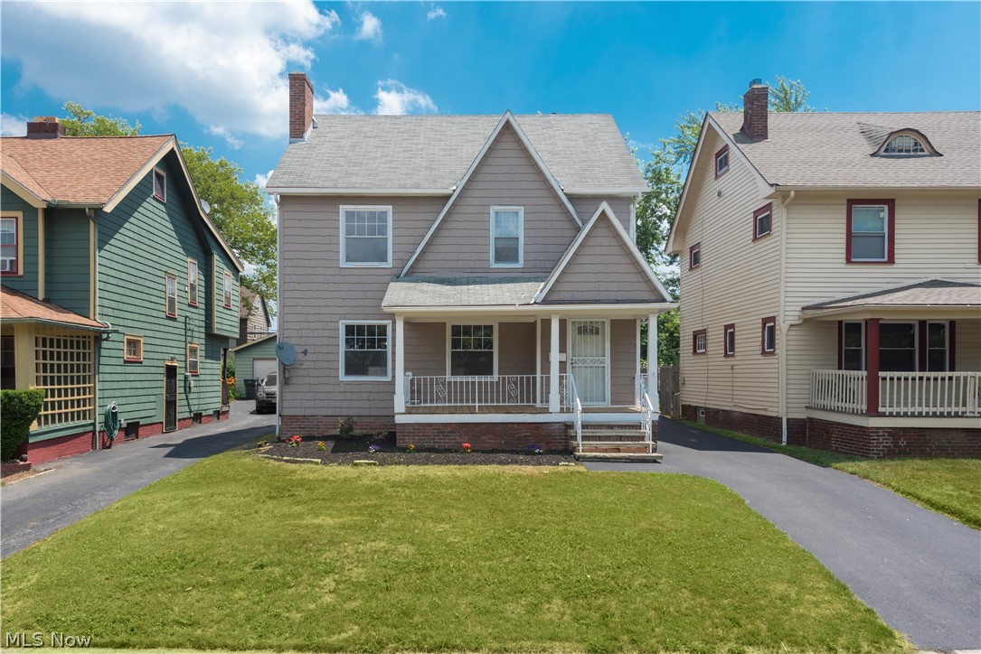View of front facade featuring covered porch and a front yard