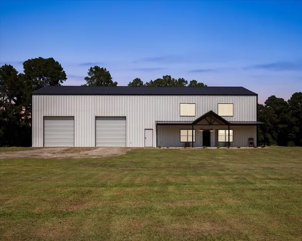 a front view of house with yard and trees in the background