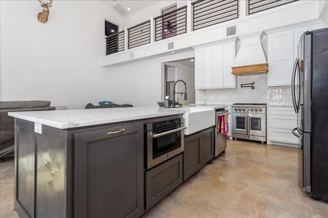 a kitchen with stainless steel appliances a stove a sink and a refrigerator