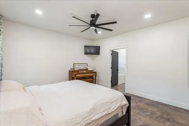 a bedroom with a bed and a ceiling fan