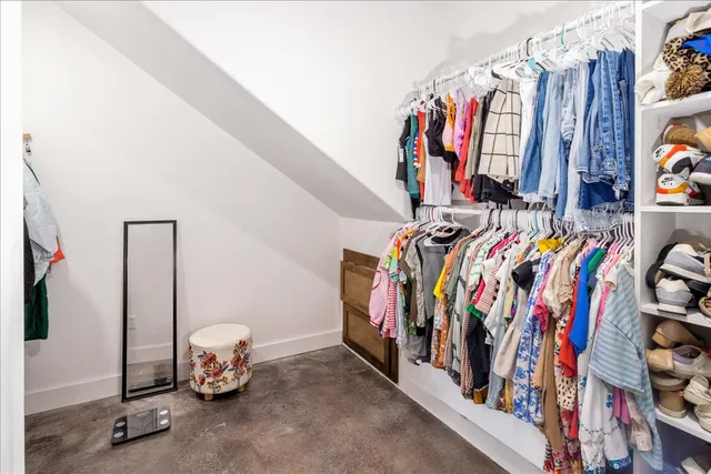 a view of walk in closet with clothes