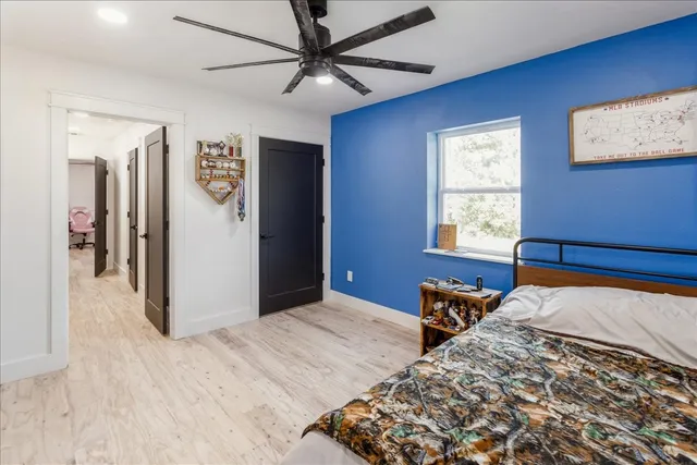 a bedroom with bed and wooden floor