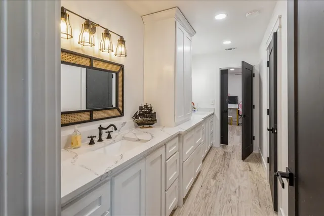 a bathroom with double vanity and a mirror