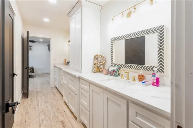 a bedroom with a bed a chair and potted plant on the dresser
