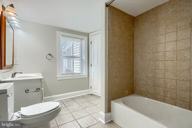 a white bath tub sitting in a bathroom next to a window