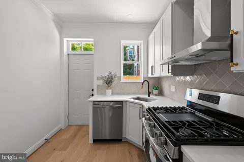 a kitchen with stainless steel appliances a sink a stove and cabinets
