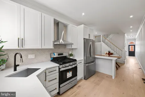 a kitchen with stainless steel appliances a sink stove and refrigerator