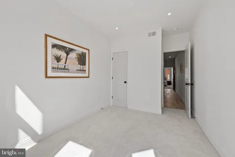 a view of an empty room with closet and a window