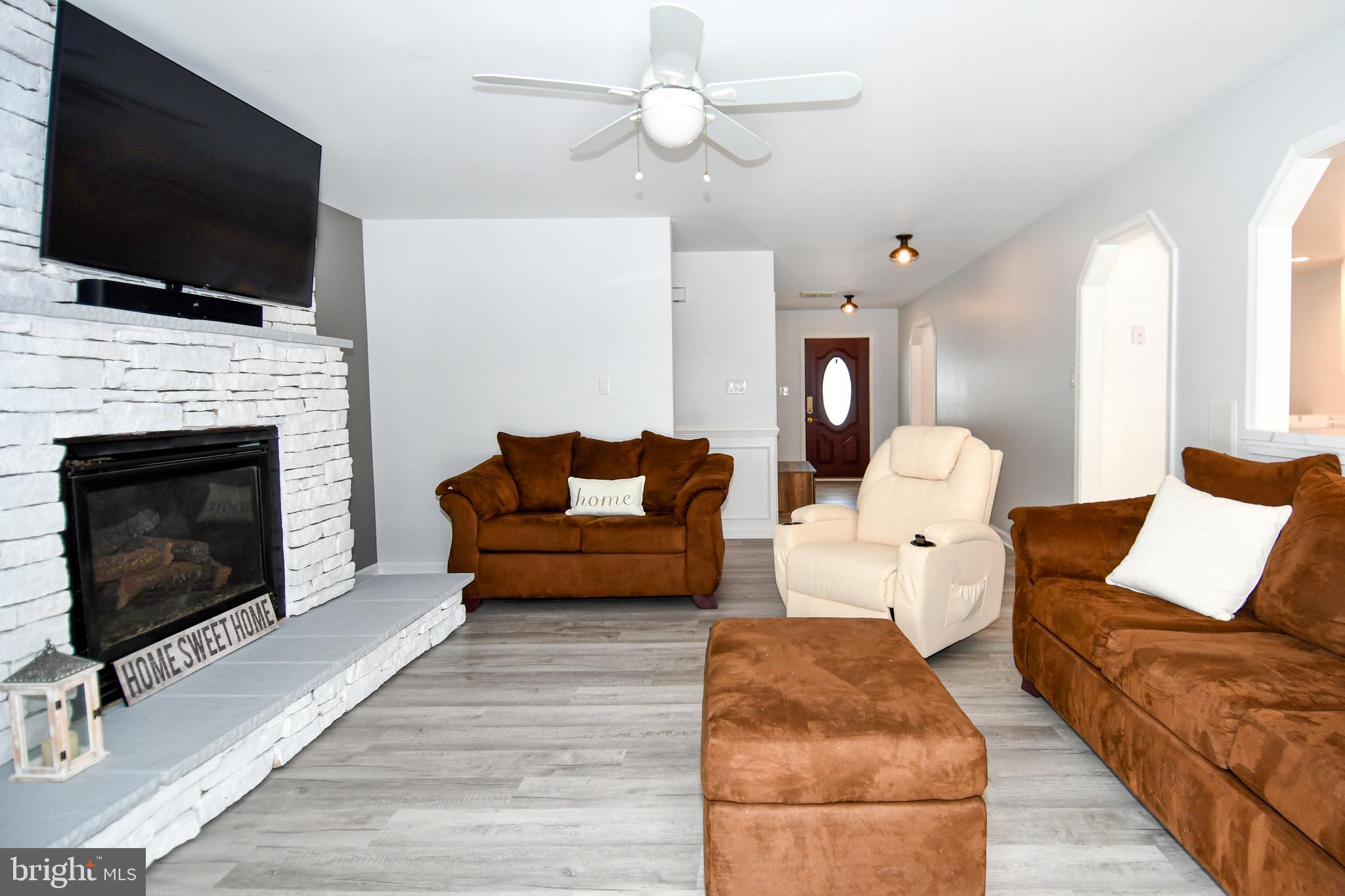 10049 Meleen Drive Faulkner, MD 20632 - Photo 6 of 56 a living room with furniture a fireplace and a flat screen tv