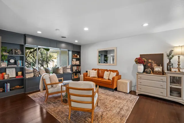 a living room with furniture a flat screen tv and a large window