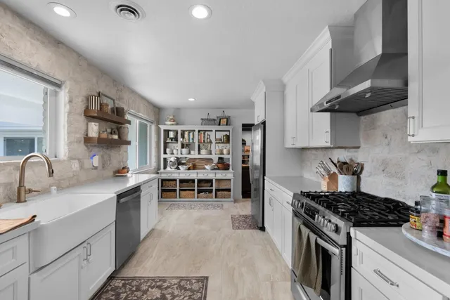 a kitchen with stainless steel appliances a stove sink and cabinets