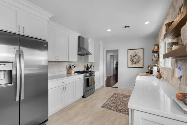 a kitchen with stainless steel appliances granite countertop a refrigerator sink and stove