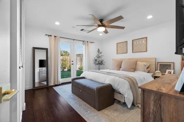 a spacious bedroom with a balcony a bed and a chandelier