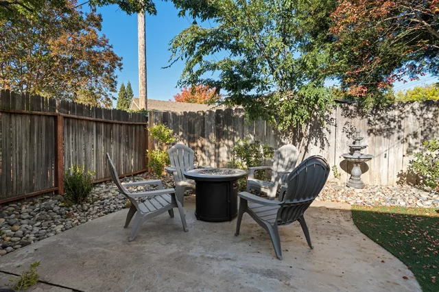 a view of a chairs and table in the backyard