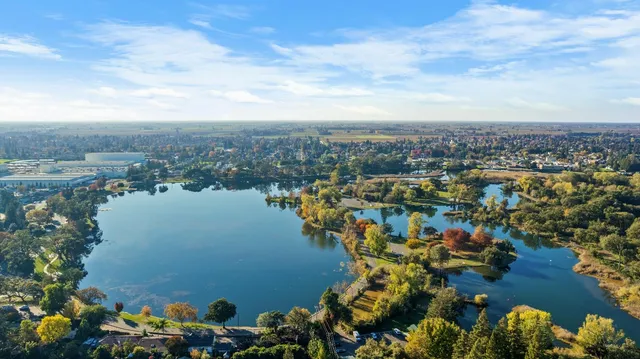an aerial view of a city with lots of residential buildings ocean and mountain view in back