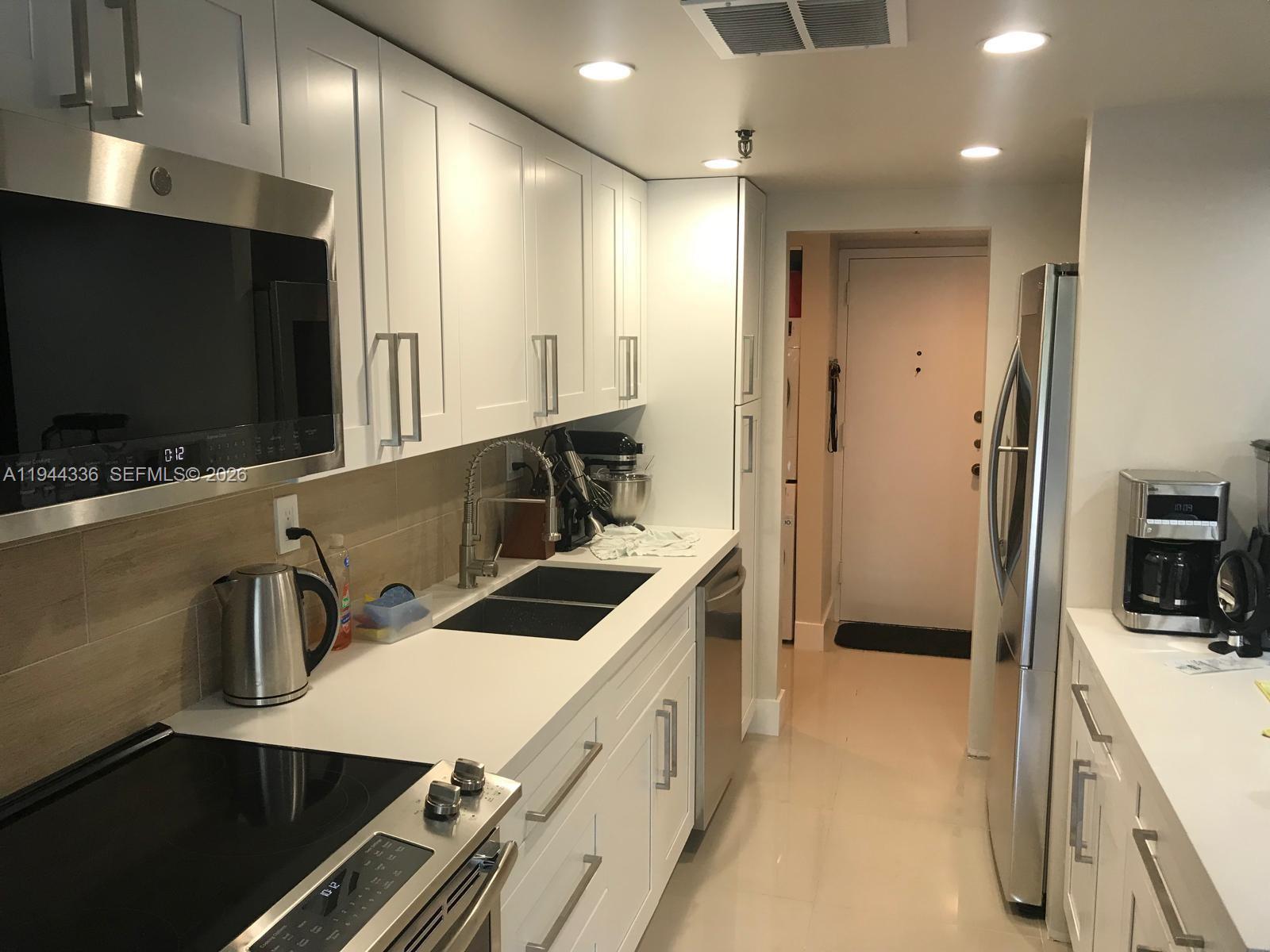 17890 West Dixie Highway, Unit 210 North Miami Beach, FL 33160 - Photo 4 of 19 a kitchen that has a sink and a stove in it