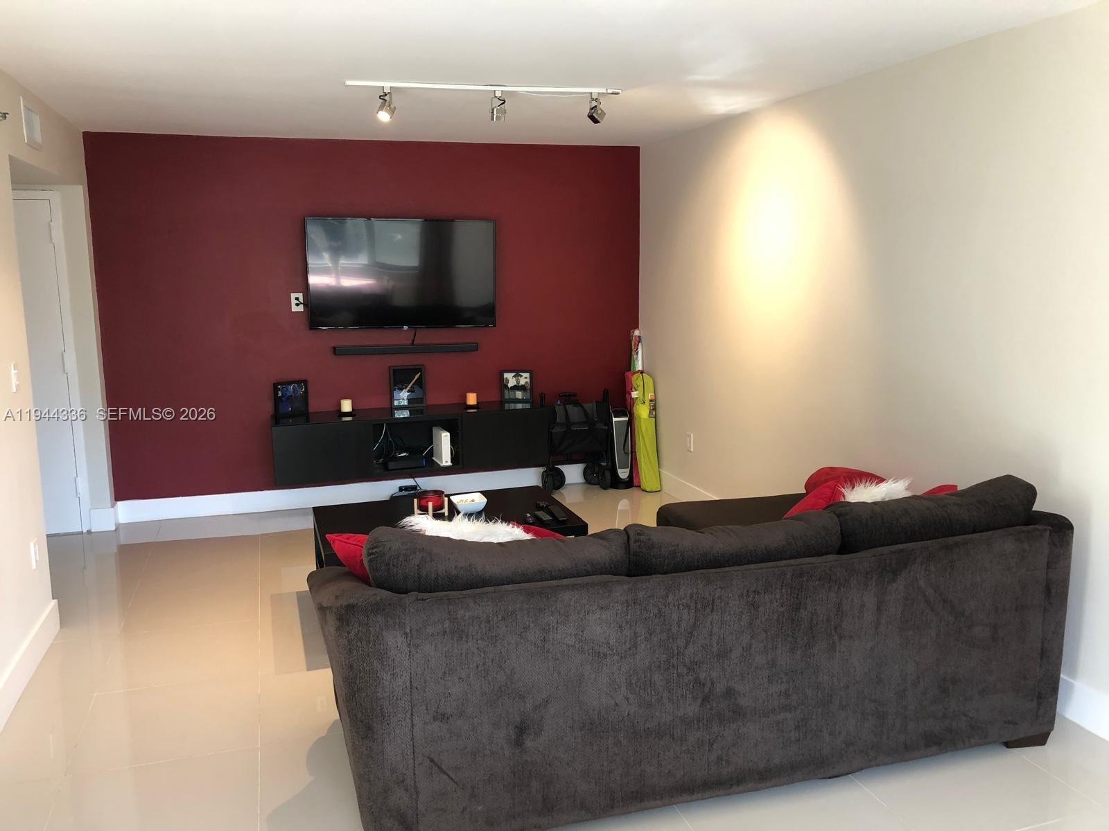 17890 West Dixie Highway, Unit 210 North Miami Beach, FL 33160 - Photo 9 of 19 a living room with furniture and a flat screen tv