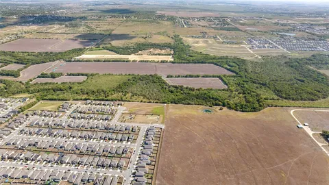 an aerial view of a house with a yard and lake view