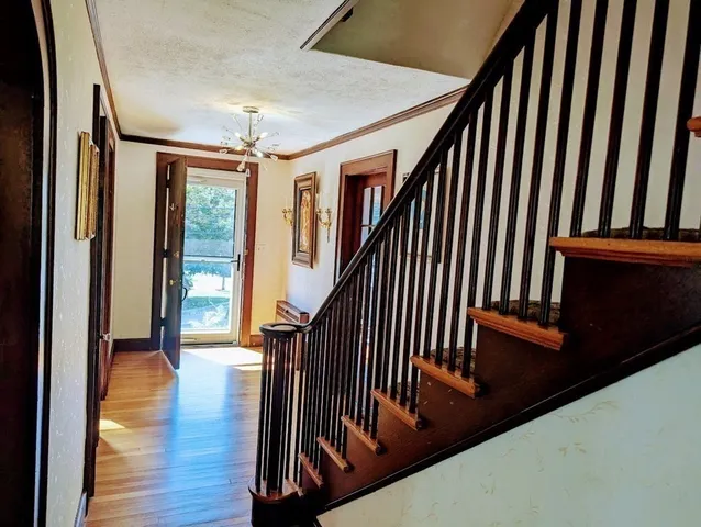 a view of a hallway with wooden floor and stairs