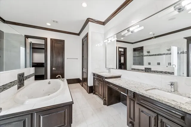 a bathroom with a granite countertop sink a large mirror and a bathtub