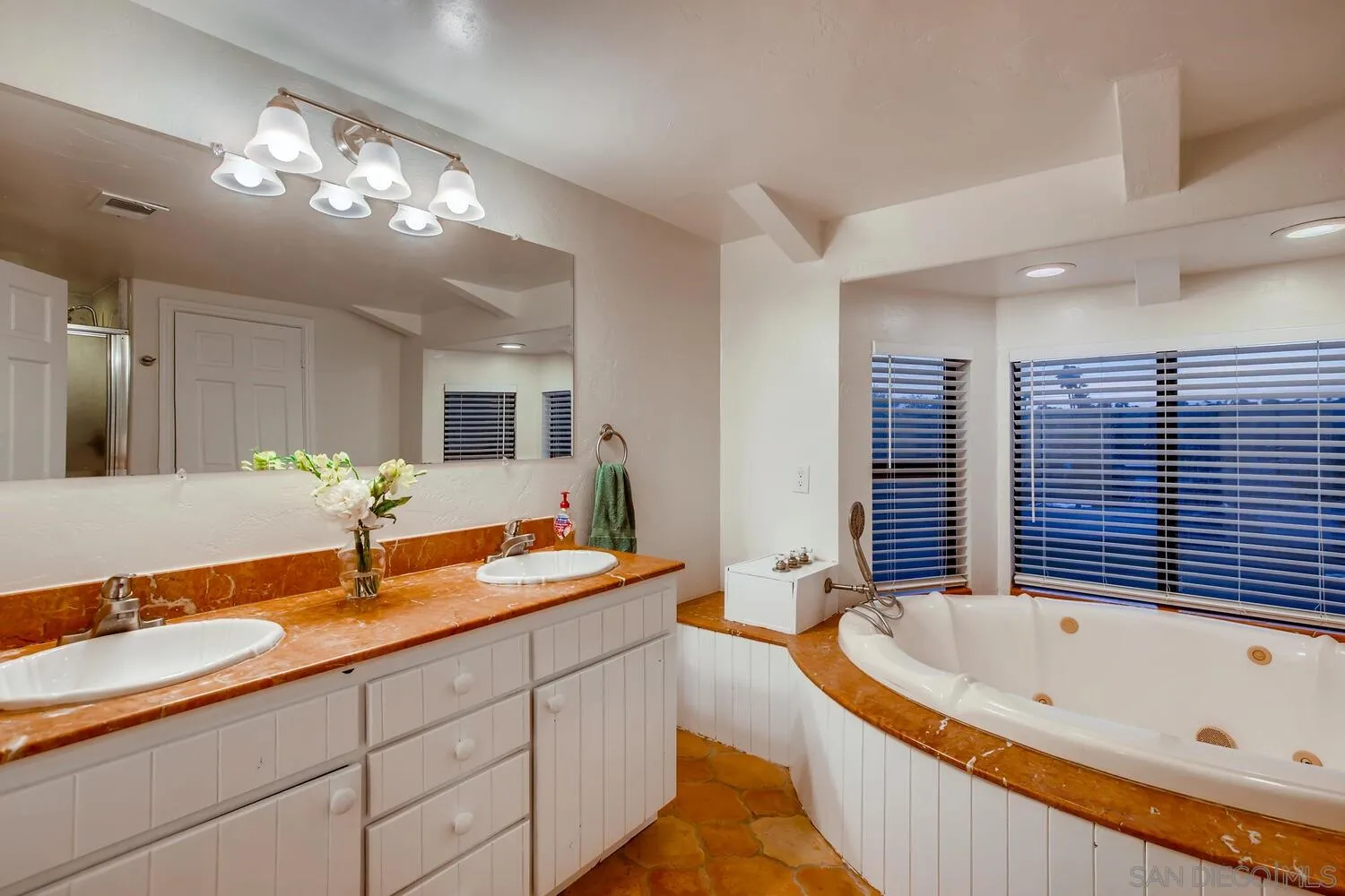 13992 Putney Road Poway, CA 92064 - Photo 24 of 38 a bathroom with a tub a double vanity sink and a large mirror