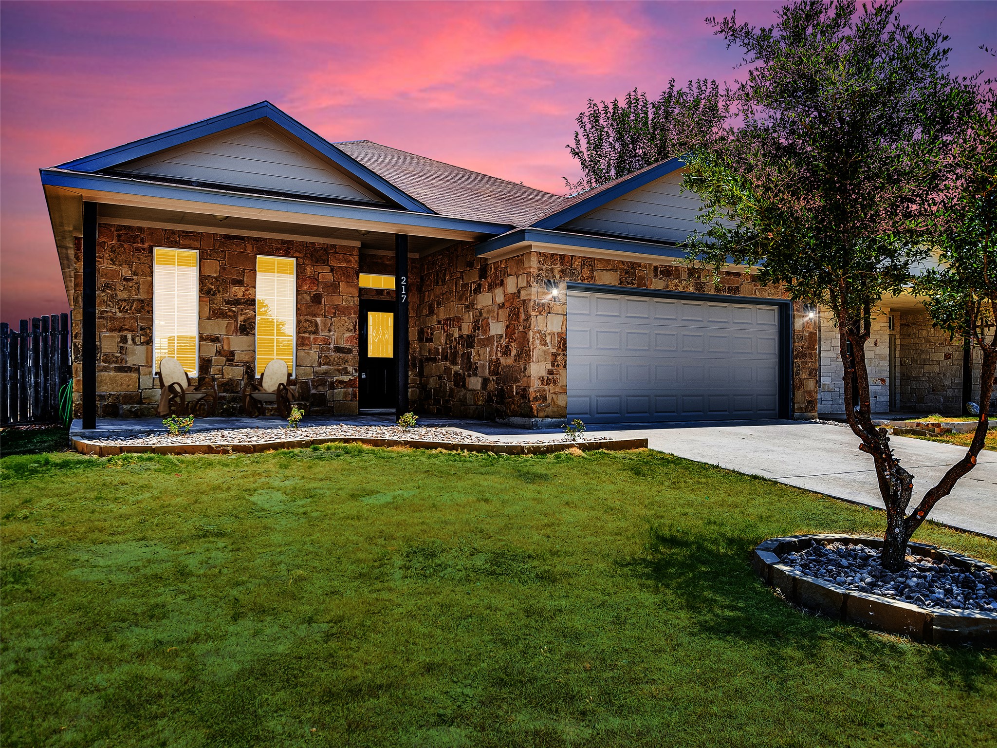 217 Geode Lane Jarrell, TX 76537 - Photo 1 of 1 Ranch-style house featuring concrete driveway, stone siding, covered porch, and a garage