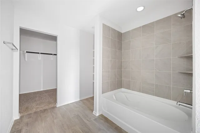 a white bath tub sitting next to a white sink and a shower