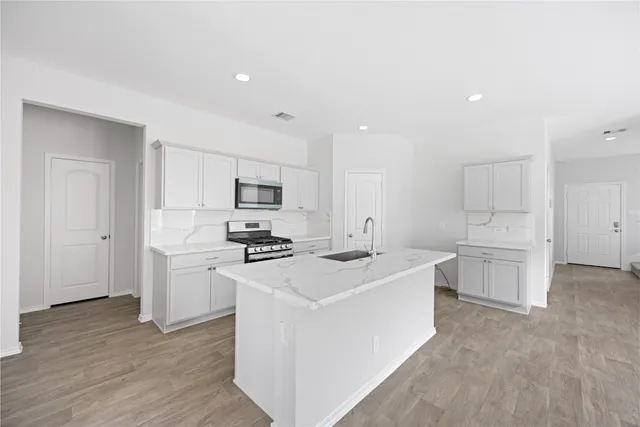 a kitchen with white cabinets and stainless steel appliances