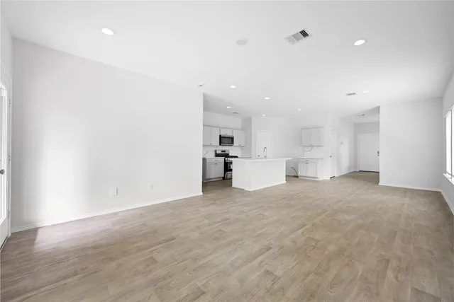 a view of kitchen with refrigerator and white cabinets