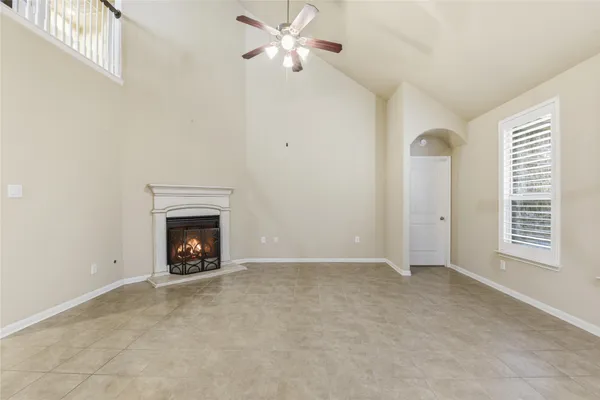 an empty room with a fireplace and fan