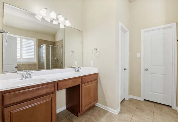 a spacious bathroom with a double vanity sink and a mirror