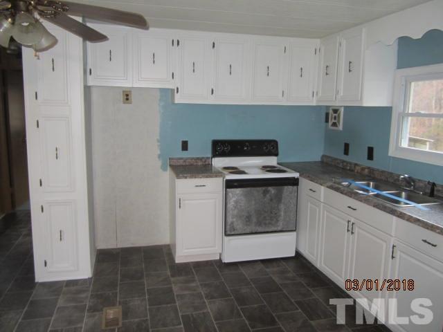 517 James Long Road Roxboro, NC 27574 - Photo 11 of 16 a kitchen with a stove sink and cabinets