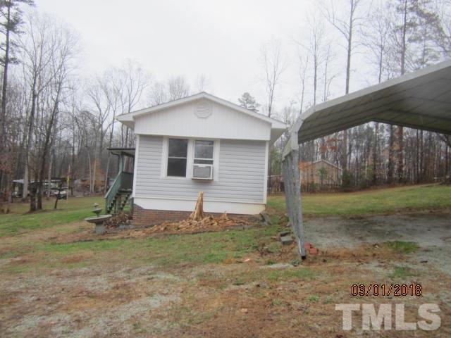 517 James Long Road Roxboro, NC 27574 - Photo 6 of 16 a view of a house with backyard and trees